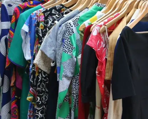 A packed wardrobe rail being walked with a phone camera